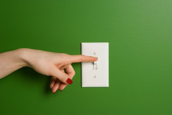 Woman Turning Off Light Switch