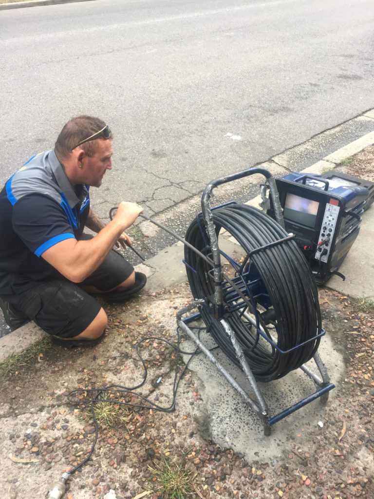 Plumber Clearing Blocked Drain