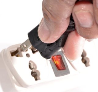 Man Plugging in an Electric Plug with Wet Hands Man Plugging in an Electric Plug with Wet Hands