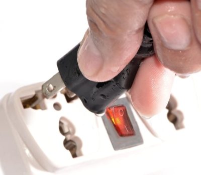 Man Plugging in an Electric Plug with Wet Hands