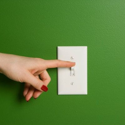 Woman Turning Off Light Switch
